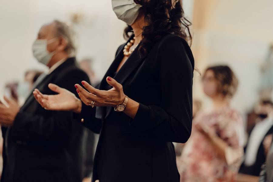 woman in black long sleeve shirt praying in church